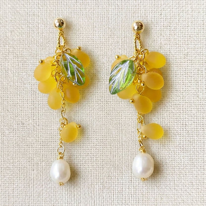 Close-up of yellow grape earrings featuring translucent Czech glass beads and gold-plated hooks