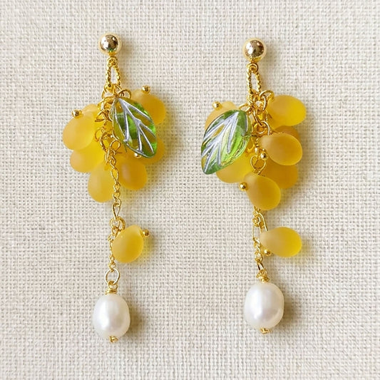 Close-up of yellow grape earrings featuring translucent Czech glass beads and gold-plated hooks
