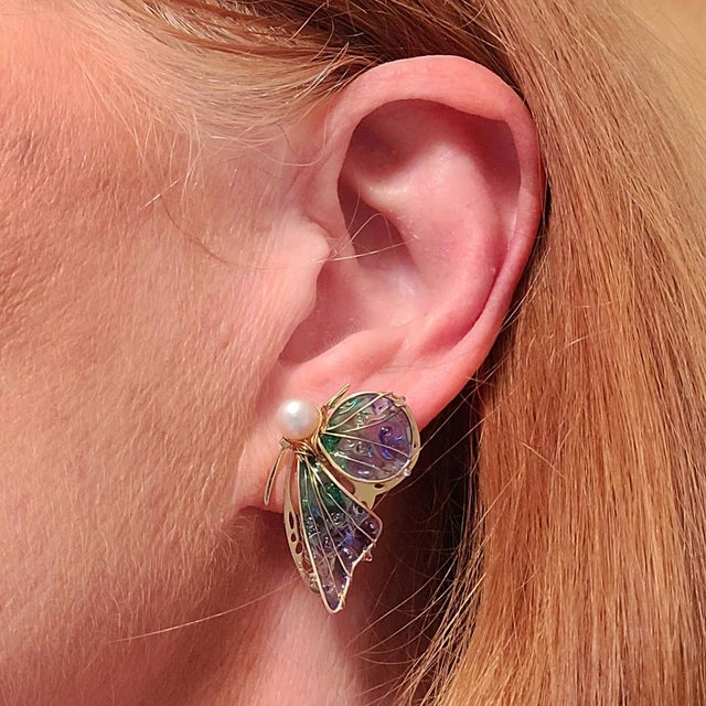 Handmade butterfly earring with green‑purple gradient wings, gold detailing and pearl accent worn by model, elegant Western‑style jewelry for women in the US and Europe