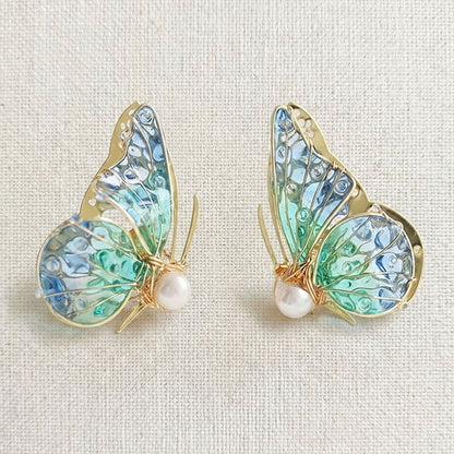 Handmade butterfly earrings with blue-green translucent wings, gold detailing and pearl accent, elegant Western-style jewelry for women in the US and Europe