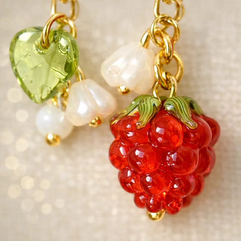 Handmade fruit-inspired charm with red raspberry glass bead, green leaf detail and pearl accents, elegant Western-style jewelry for women in the US and Europe