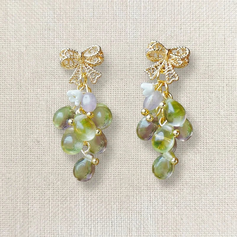 Handmade grape‑inspired earrings with gold bow, green and purple translucent beads and pearl accents, elegant Western‑style jewelry for women in the US and Europe