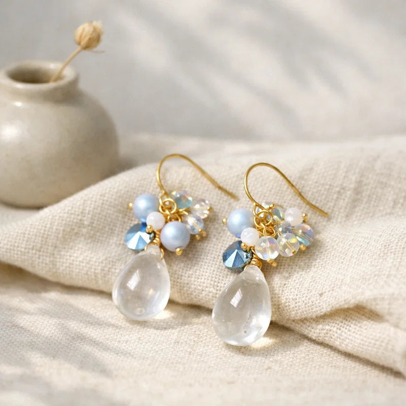 Handmade teardrop crystal earrings with clear gemstone, blue and white bead cluster and gold detailing, elegant Western‑style jewelry for women in the US and Europe