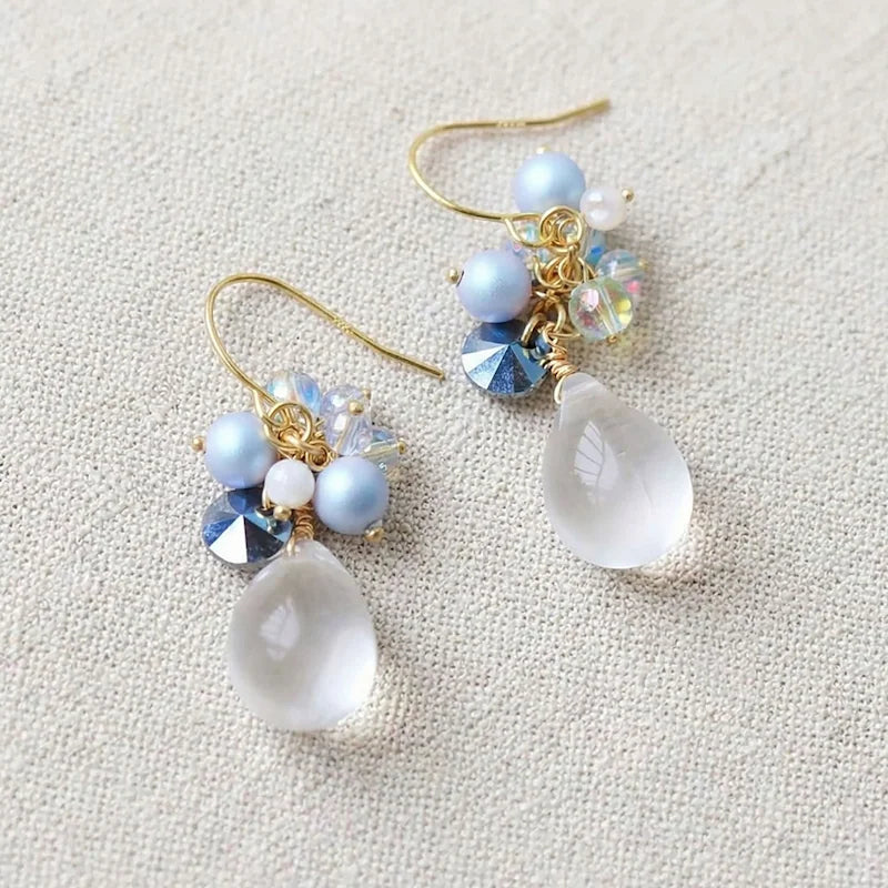 Handmade teardrop crystal earrings with clear gemstone, blue pearl cluster and iridescent accents on gold hook, elegant Western‑style jewelry for women in the US and Europe
