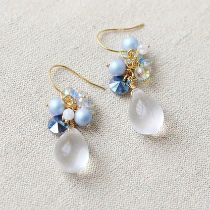 Handmade teardrop crystal earrings with clear gemstone, blue pearl cluster and iridescent accents on gold hook, elegant Western‑style jewelry for women in the US and Europe
