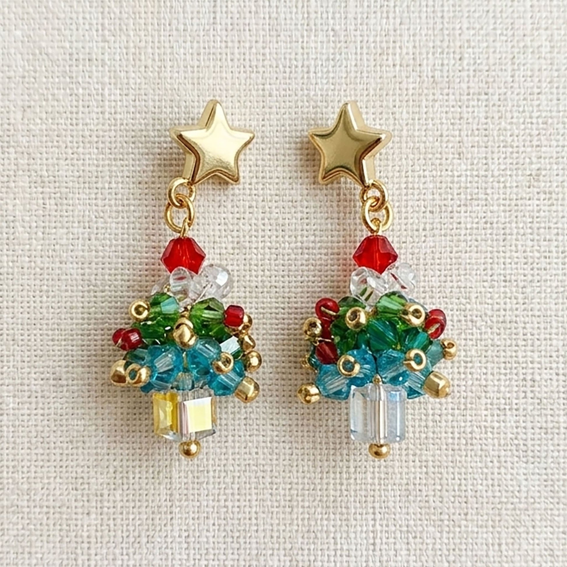 Lifestyle shot of a woman wearing festive Christmas tree drop earrings at a holiday dinner party