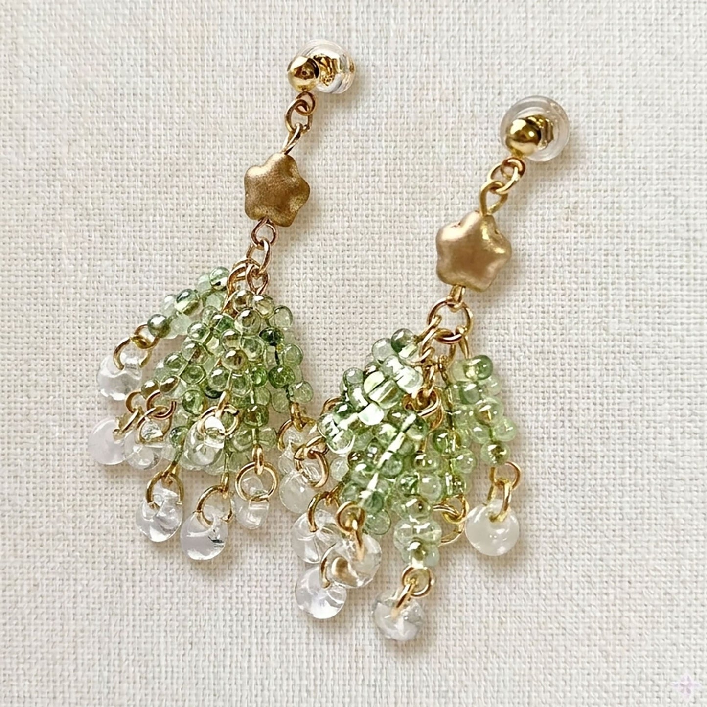 Pair of handmade Czech glass Christmas tree earrings featuring tiered green beads and a gold star topper