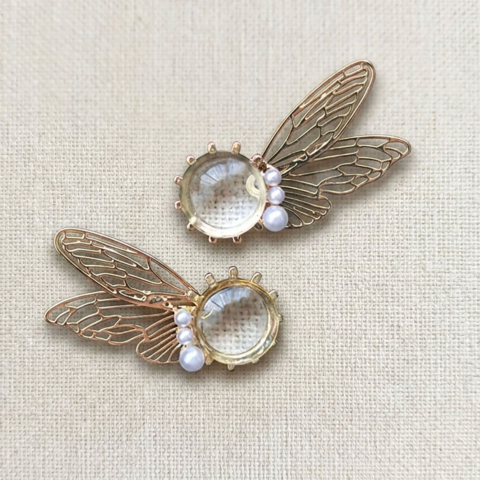 Side view of transparent iridescent fairy wing earrings catching the sunlight
