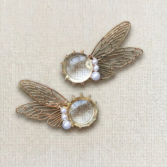 Side view of transparent iridescent fairy wing earrings catching the sunlight